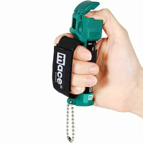 A person holding a green Mace® Canine Repellent modified with a chain attached to it for added safety and control.