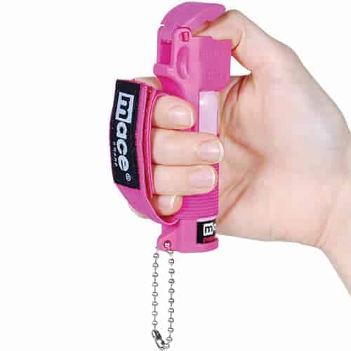 A jogger holding Mace® Pepper Spray Jogger - Pink.