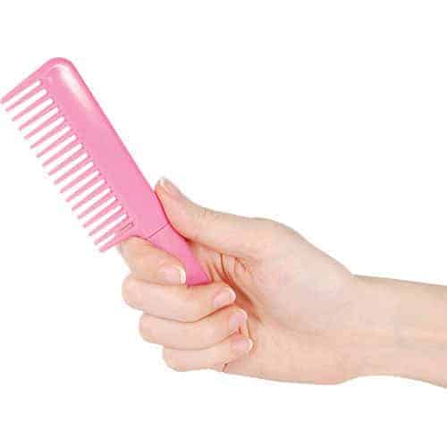 A woman's hand holding a Comb Metal Knife.
