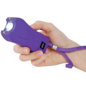 A hand gripping a Runt Rechargeable Stun Gun With Flashlight And Wrist Strap Disable Pin.