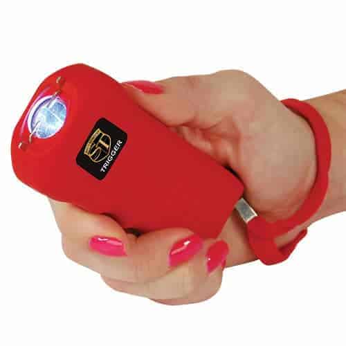 A woman gripping a red Trigger Stun Gun Flashlight with Disable Pin in her hand.