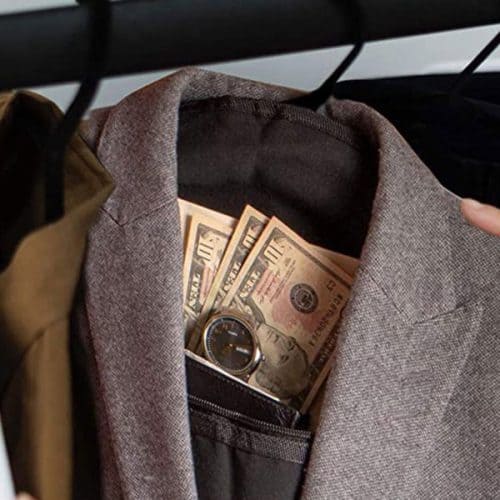 A man is discreetly slipping money into a Hanger Diversion Safe hidden pocket on his jacket.