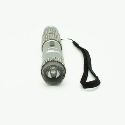 The RhineStun 75,000,000* Stun Flashlight shines elegantly with silver rhinestone details and a black wrist strap, presented front-on against a clean white backdrop.