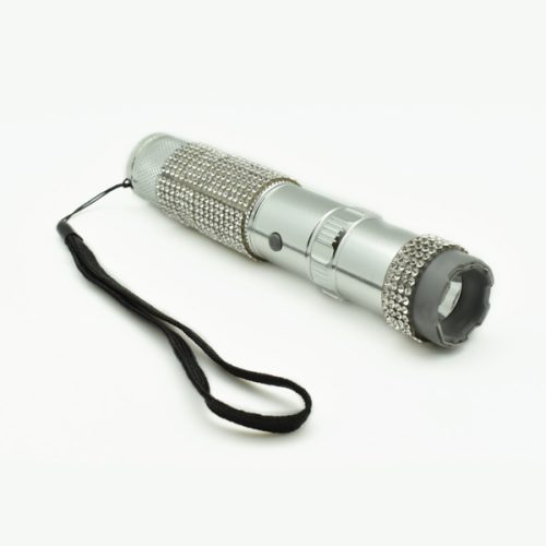 The RhineStun 75,000,000* Stun Flashlight features rhinestone embellishments and a practical black wrist strap. Its sleek silver design makes it both stylish and functional against a pristine white background.