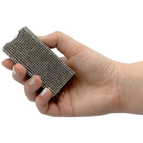 A hand holding the Rhinestun Keychain Stun Gun dazzles with its sparkling rhinestone-covered brilliance, blending elegance and self-defense unexpectedly.