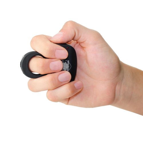 A hand grips a sleek, black Sting Ring 18,000,000* Stun Gun, an oval-shaped device with a button on top.